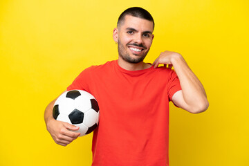Young caucasian man playing soccer isolated on yellow background laughing