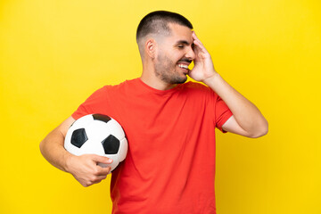 Young caucasian man playing soccer isolated on yellow background smiling a lot