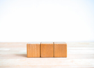 3 wood blocks isolated on wooden table, white banner background with copy space. Empty blank...