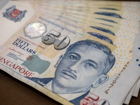 Singapore dollar money background. Several Close-up 50 Singapore dollars currency banknote bills were unfolded. Business finance and banking concept.
