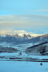 Cold snowy mountain landscape at sunset.