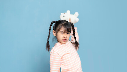 Little girl is throwing dolls and destroying things. little girl is angry.