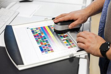 Printing factory worker with color reference card
