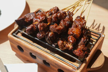 Homemade lamb or mutton satay marinated with spice and sweet soy sauce, coriander goat satay, served with chilli, soy sauce and tomato. Indonesian traditional satay