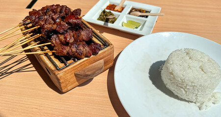 Homemade lamb or mutton satay marinated with spice and sweet soy sauce, coriander goat satay, served with chilli, soy sauce and tomato. Indonesian traditional satay