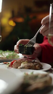 Detailed ambiance description of a person enjoying wine and a gourmet meal in an elegant dining setting