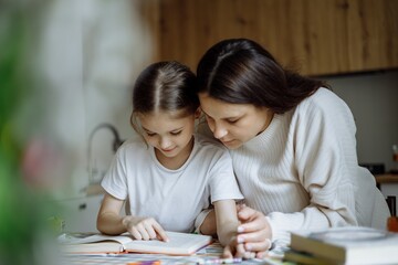 The daughter and her mother do their school homework