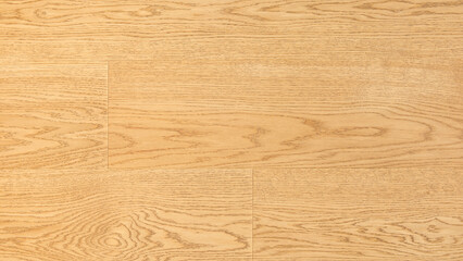 A wooden surface with a grainy texture. The wood is brown and has a natural look. The surface is smooth and has a warm, inviting feel