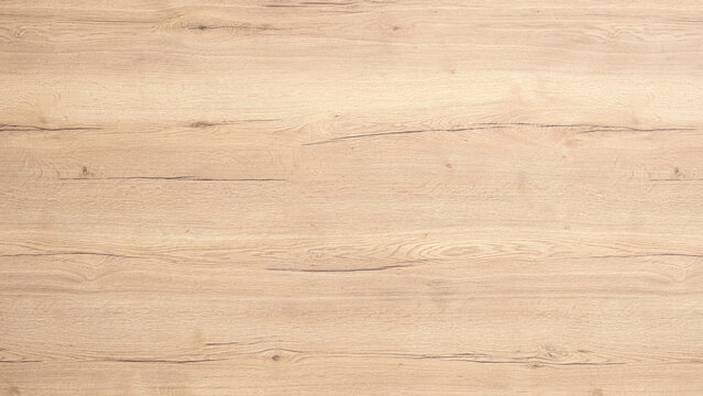 A wooden surface with a grainy texture. The wood is brown and has a natural look. The surface is smooth and has a warm, inviting feel