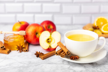 Fragrant hot tea with cinnamon stick and anise on a textured wooden background. A cup of hot tea...