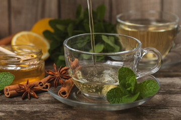 Fragrant hot tea with cinnamon stick and anise on a textured wooden background. A cup of hot tea...