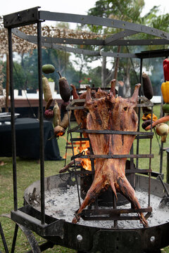 Chivito asado a la llama, vertical, colorido