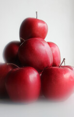 Perfect juicy red apples stacked in a heap on a white background in heavenly style
