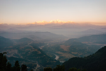 Stunning sunrise view over the misty valley of Bandipur, Nepal, with the majestic Himalayas illuminated in the distance.