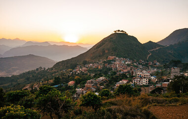 Golden hour over the quaint town of Bandipur, Nepal, nestled between rolling hills with a stunning...