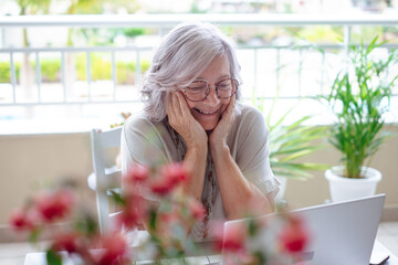 Video call. Happy smiling senior gray haired woman talking with distant friend or family people by...