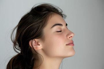 A close up of a woman's face with her eyes closed looking to a side