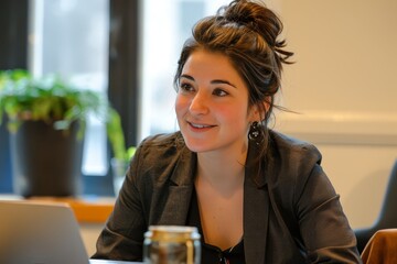 a beautiful woman with short hair sitting in front of a laptop