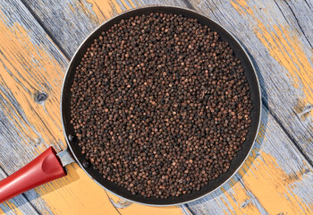 tawa filled with black peppers (Piper nigrum). Native to Malabar coast of India, it is widely used in culinary as spice and seasoning around the world.