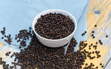 bowls filled with black peppers (Piper nigrum). Native to Malabar coast of India, it is widely used in culinary as spice and seasoning around the world.