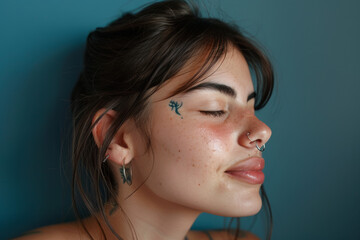 A close up of a woman with tattoos and piercings looking to a side