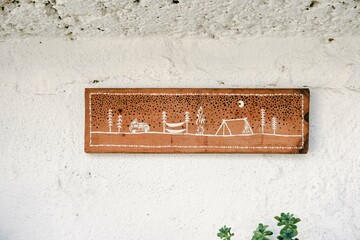 Camping theme drawn on a piece of wood on the wall with succulent flower. Bohemian decor