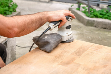 Close-up of using a circular sanding machine. To build a new house
