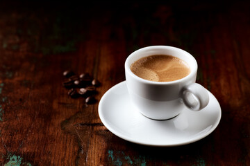 Cup of coffee on wooden background. Close up.