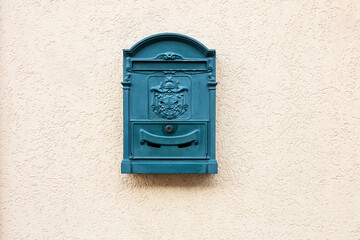 Traditional old turquoise post box on pastel plaster texture wall in Hungry. Metal green blue...