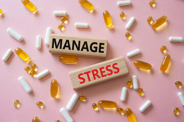 Manage stress symbol. Concept word Manage stress on wooden blocks. Beautiful pink background with...
