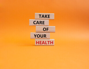 Health symbol. Wooden blocks with words Take Care of your Health. Beautiful orange background....