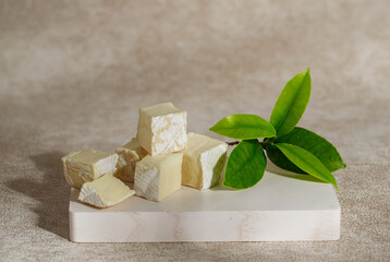 Jewish holiday Shavuot concept with pieces of cheese on a white wooden board.