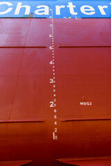 Cargo vessel in dry dock on ship repairing yard. Draught marks.