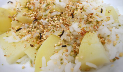 close up of rice. background of rice. White rice with potatoes and furikake. details of the meal. food with a selective focus. rice with seasoning.