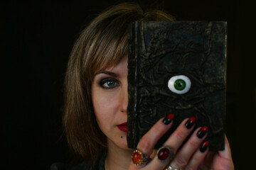 a witch woman with an occult book