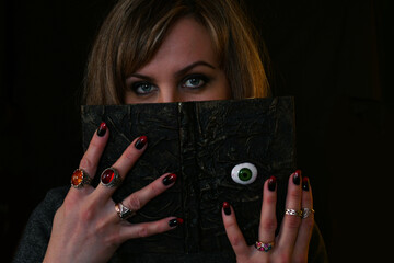 a witch woman with an occult book