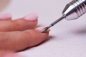 process of performing a manicure with a diamond cutter close up