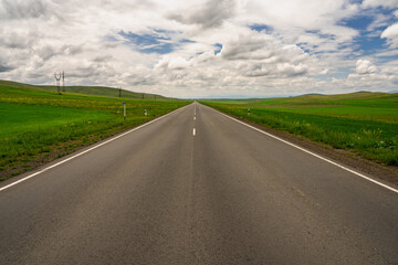 Fototapeta premium Asphalt road, grassy sidewalks, travel concept