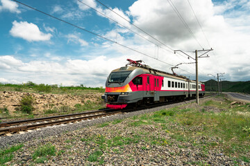 Obraz premium red train on railway track in nature, travel concept