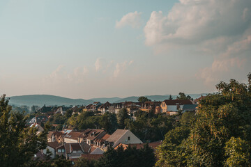 Obraz premium Orange brown tiled roof of the houses with solar panels. Traditional street. Amazing landscape with mountains and houses of Eger. Different size and colors building in Europe. Lifestyle of Hungary.