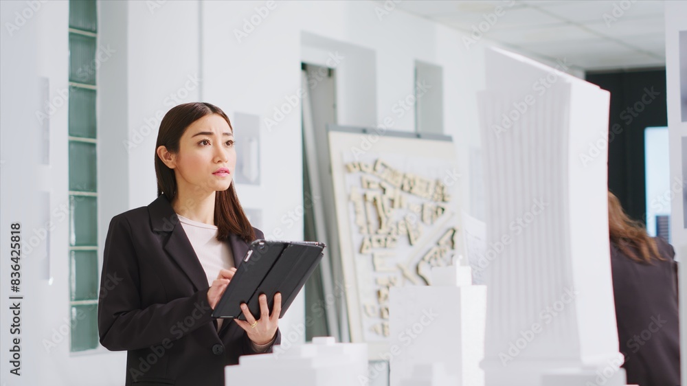 Poster in property management office, contractor uses tablet to evaluate and estimate variables as they wor