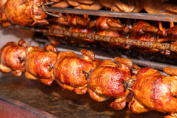 Rotisserie chicken cooking on a spit with golden crispy skin
