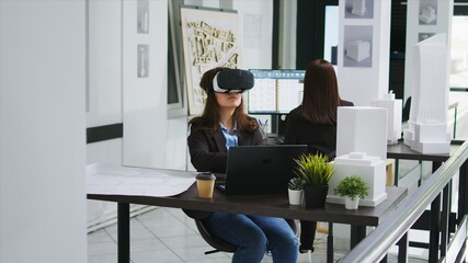 Woman architect working with vr glasses in startup office, modeling floor plan or house blueprint...