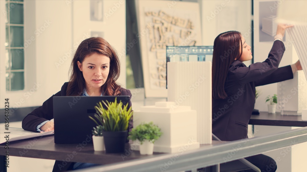 Poster pov of designer interacting with client via videocall connection to review architectural plan propos