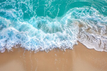 Naklejka premium Sandy beach and soft blue ocean wave top view. Summer background