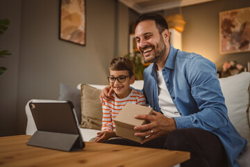 Father and son surprise somebody with gift via video call on tablet