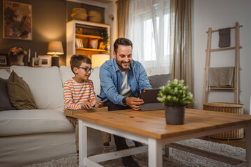Father hold credit card buy online on tablet while son hold package