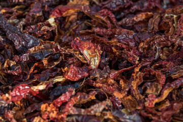 Top view of pile of dried red hot chili peppers. Hot peppers drying in the sun, showcasing texture and spicy ingredient concept.