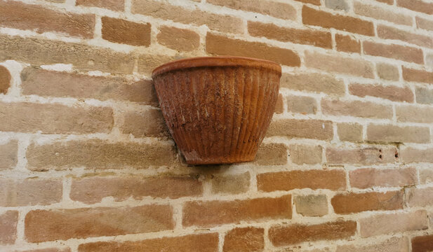Vaso di terracotta rossa su muro di mattoni