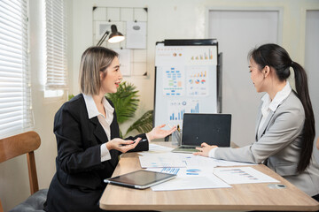 Asian business group discussing graph work at the office